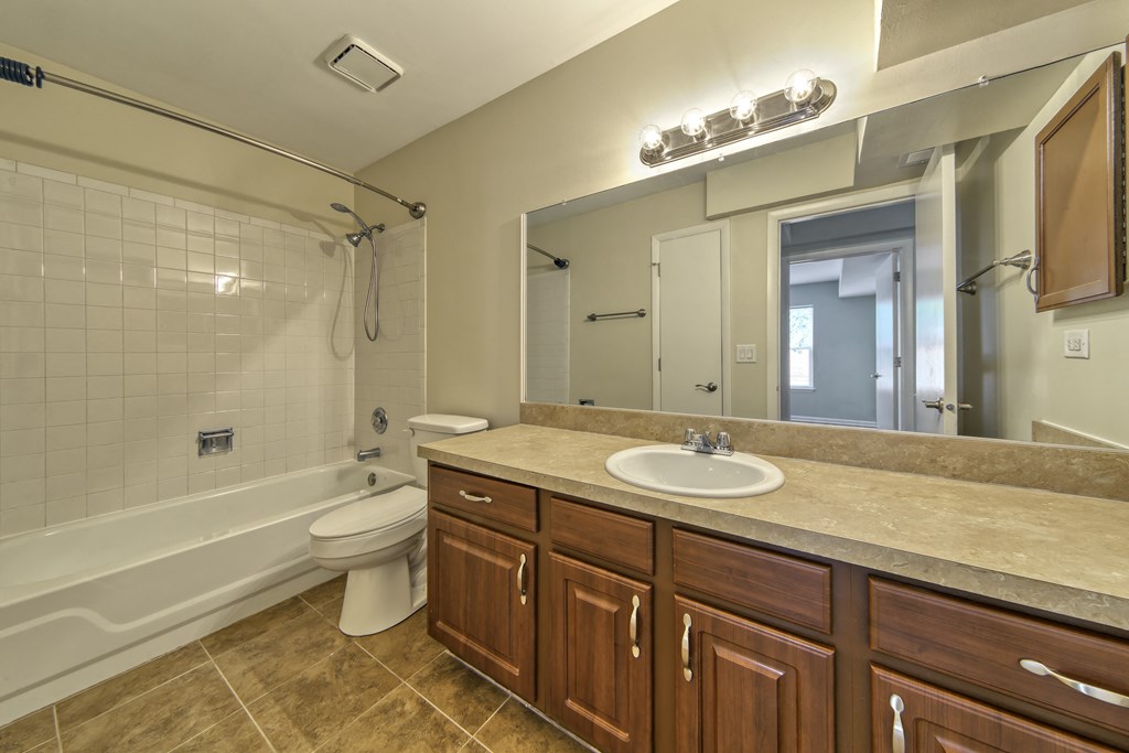 a bathroom with a sink toilet and shower and a mirror