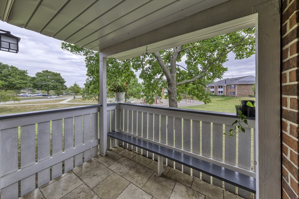 the view from the porch of a house with a porch swing