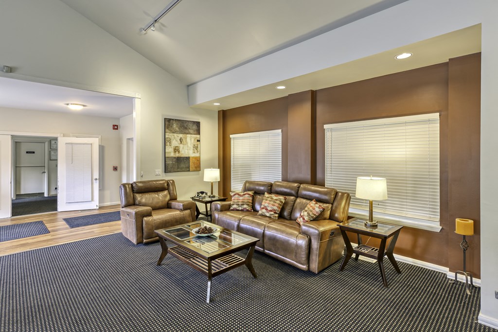 a living room with leather couches and chairs and a table