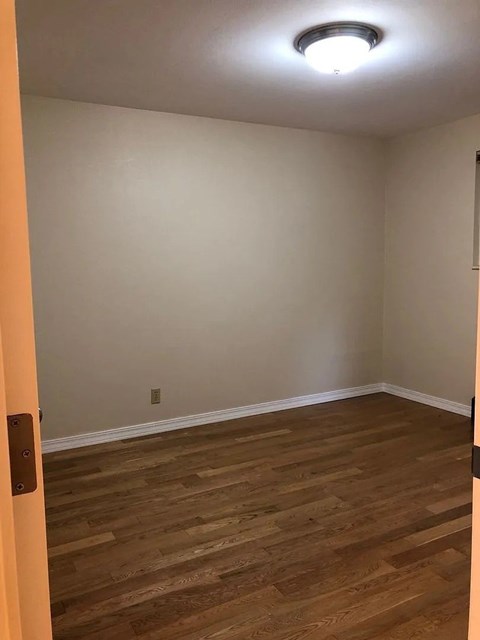 A room with wooden flooring and a light on the ceiling.