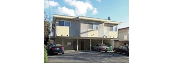 A two-story building with a garage and a car parked in front.