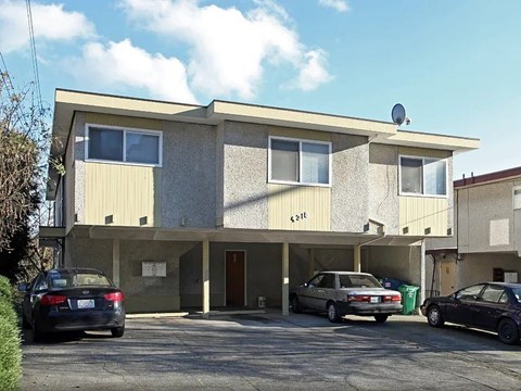 A two-story building with a garage and a car parked in front.