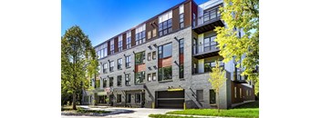 a brick building with a parking lot and trees