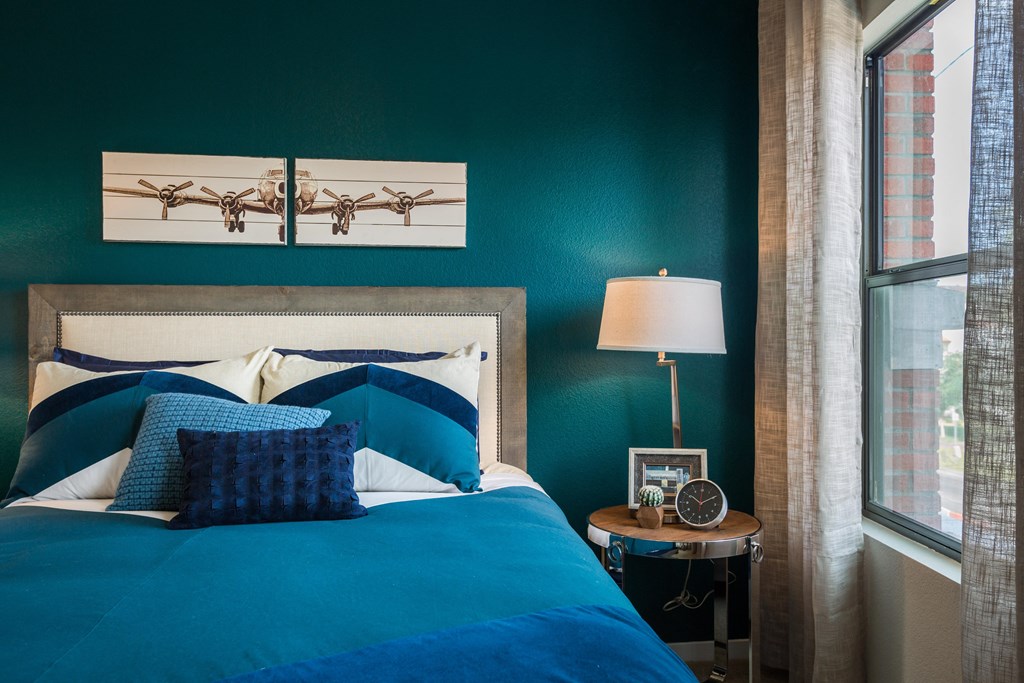 Bedroom With Bed And Side Table With Large Window At Union at Roosevelt Apartments In Phoenix, AZ