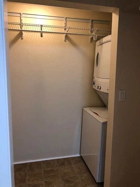 A white dryer is in a small laundry room.