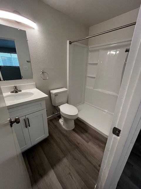 A white bathroom with a toilet, sink, and mirror.