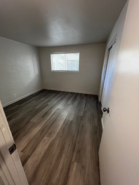 A room with wooden flooring and a window.