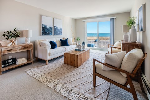 A living room with a white couch and a wooden chair.