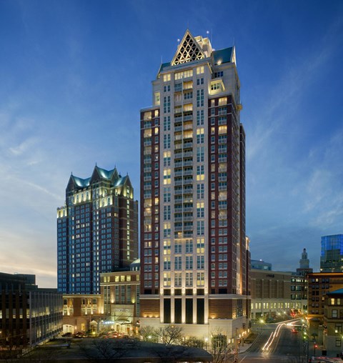 A tall building with a pointed top is lit up at dusk at Residences Providence, Providence