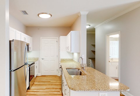 a kitchen with a granite counter top and a stainless steel refrigerator