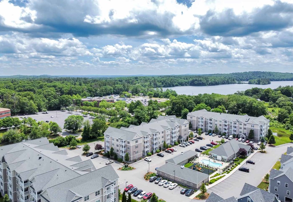 Village Green Apartments in Littleton with pool, playground and Lake Nagog in background