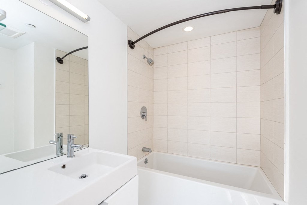 a bathroom with a sink and a tub and a mirror