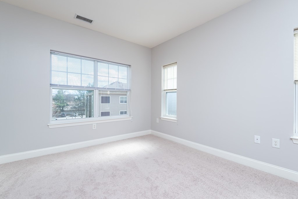 Drum hill one bedroom apartment bedroom with plush carpeting and large windows