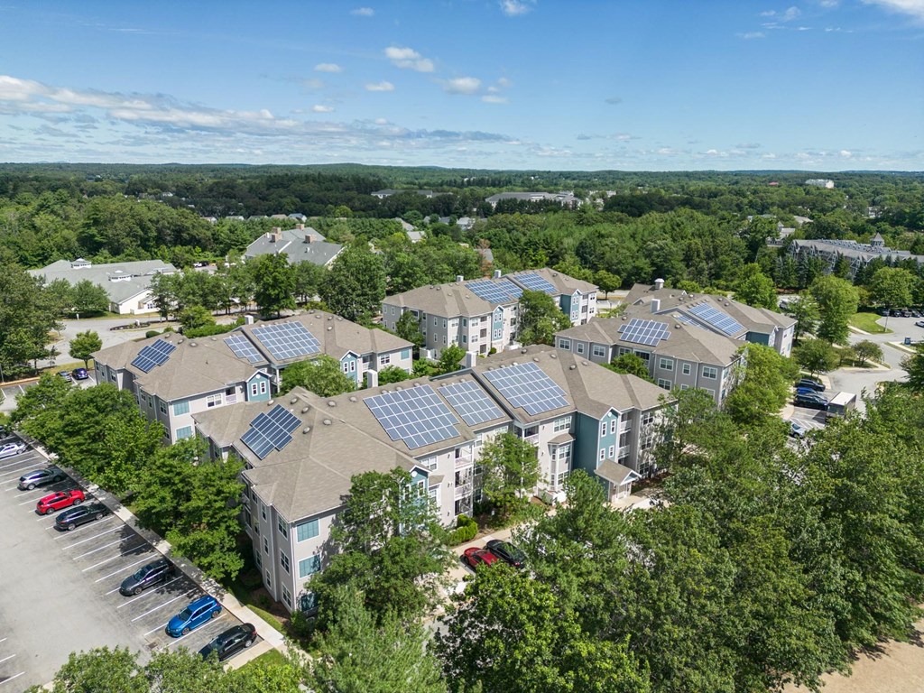 A bird's eye view of a residential area with houses and solar panels on the roofs.