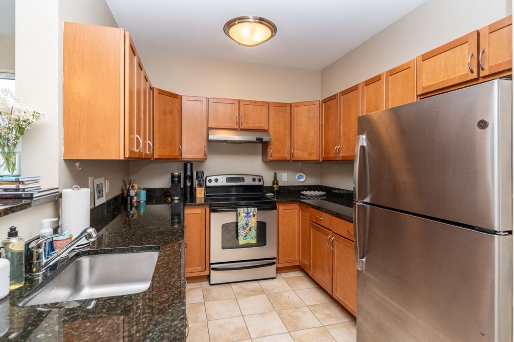 50 WB's furnished apartment showing full kitchen with stainless steel appliances and granite counter tops