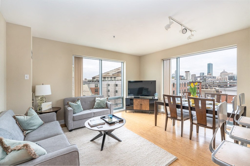 50 WB's furnished apartment showing a living room with a couch and a table and a large window