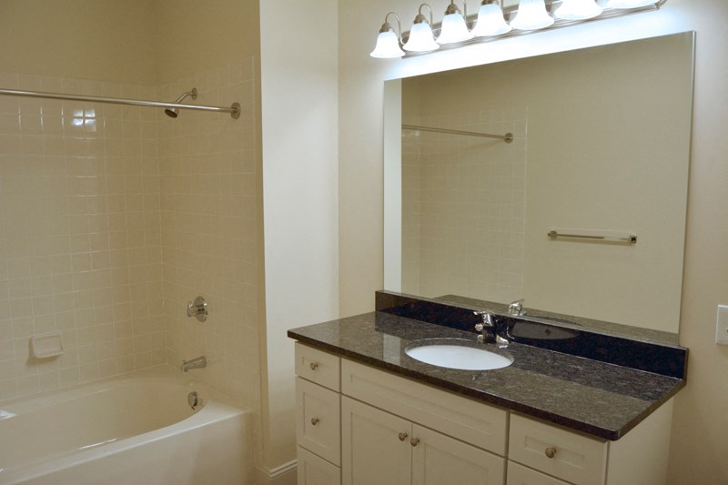 bathroom with large mirror and white finisehs