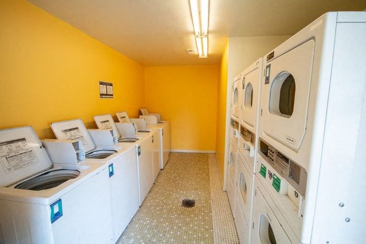 a laundry room filled with white washes and dryers