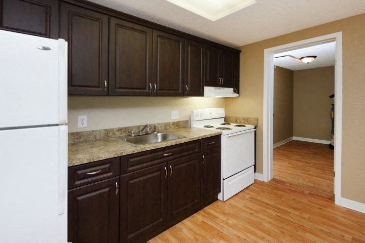 a kitchen with white appliances and brown cabinets
