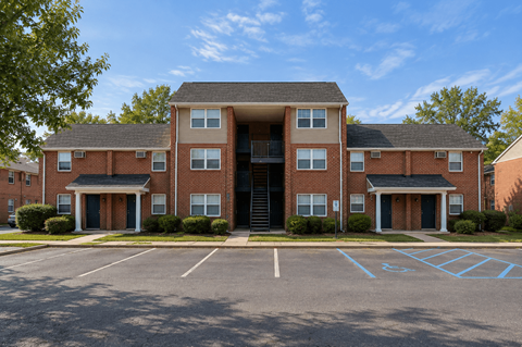 A large brick building with a parking lot in front.