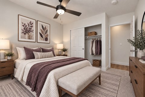 A bedroom with a large bed and a ceiling fan.