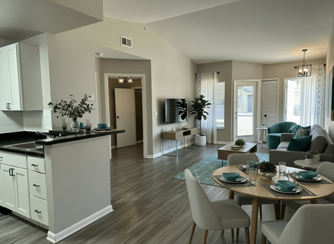 A modern kitchen with a dining table set for four.
