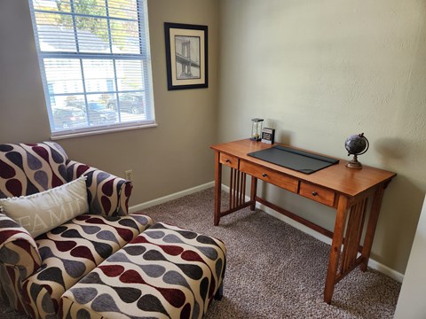 A living room with a couch and a desk.