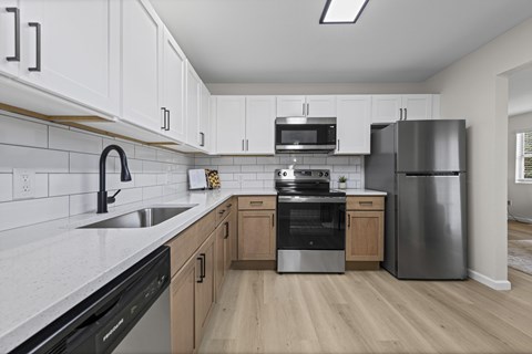 A kitchen with a black dishwasher and stove top oven.