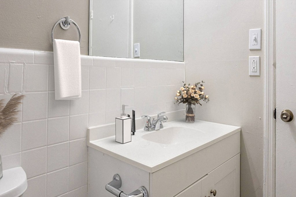 a white bathroom with a sink and a mirror