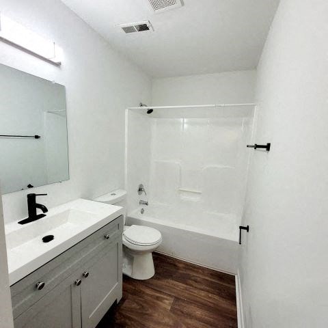 a white bathroom with a toilet and a sink