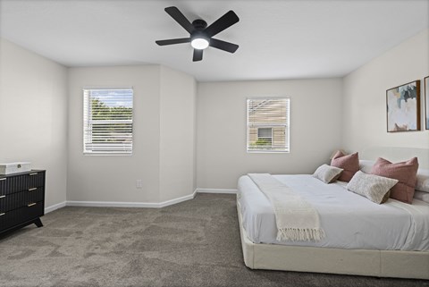A bedroom with a bed, dresser, and window.