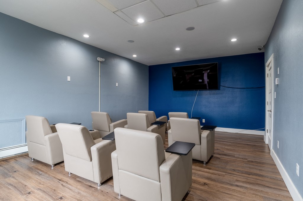 a cinema room with blue walls and white chairs