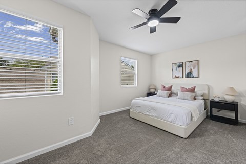 A bedroom with a bed, nightstand, and a ceiling fan.
