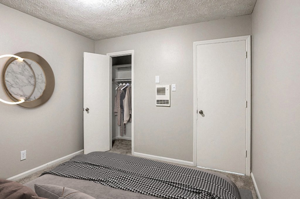 an empty bedroom with a bed and a closet