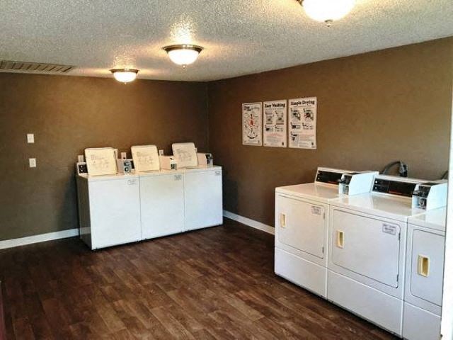a laundry room with four washer and dryer machines