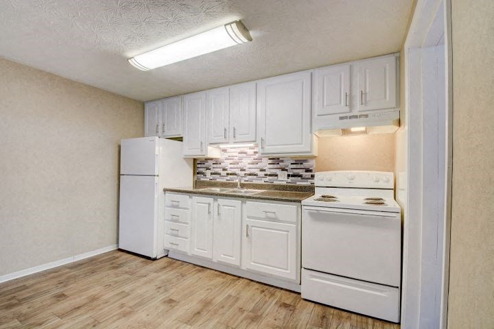 a white kitchen with white appliances and white cabinets