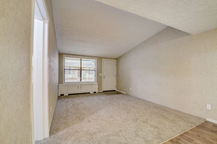 an empty living room with a window and a door