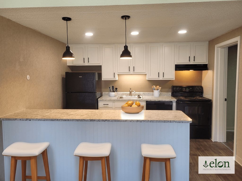 A kitchen with a counter and bar stools.