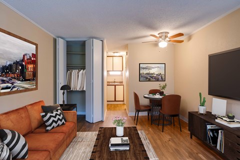 A living room with a brown couch, a coffee table, and a painting on the wall.