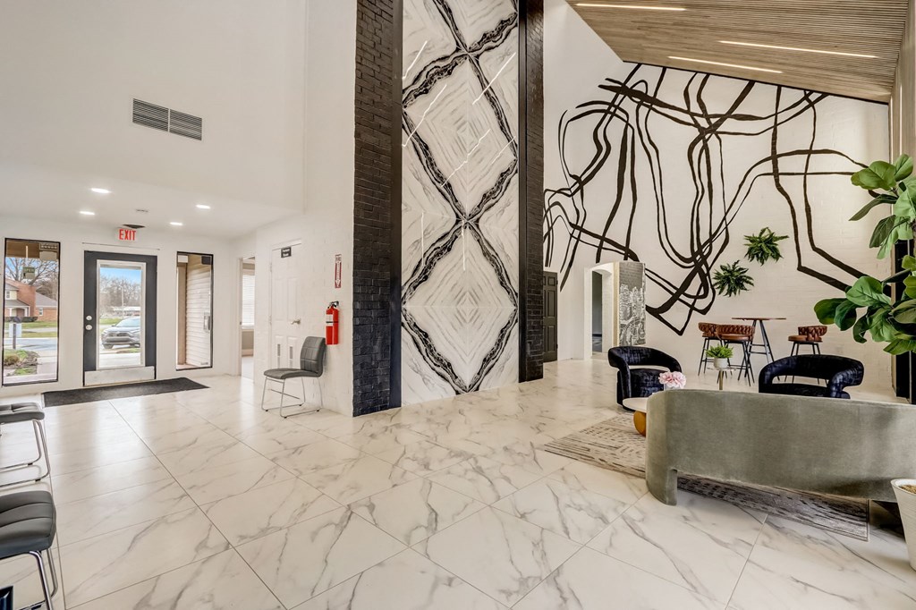 a lobby with marble flooring and a wall with a black and white wallpaper