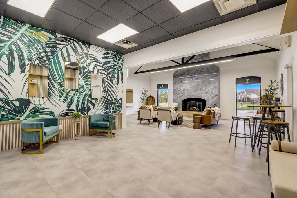 the lobby of a building with tables and chairs and a fireplace