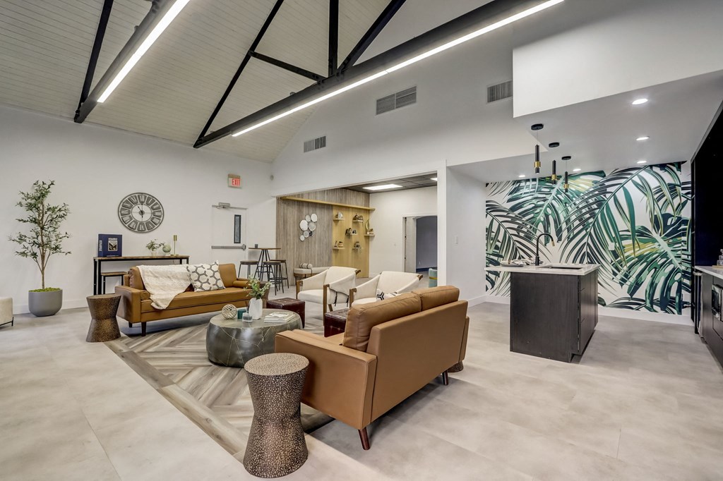 a lobby with couches and chairs and a clock on the wall