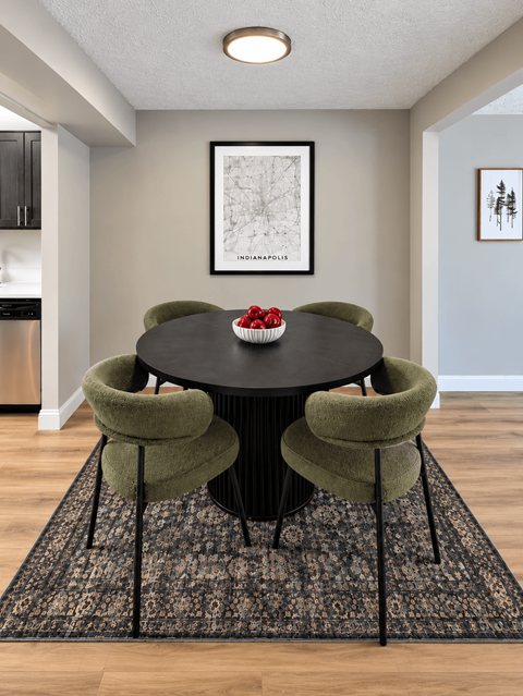 A dining room with a black table and green chairs.