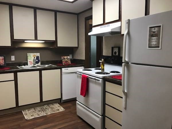 A kitchen with white appliances and wooden cabinets.