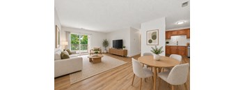 A living room with a couch, chairs, and a television.