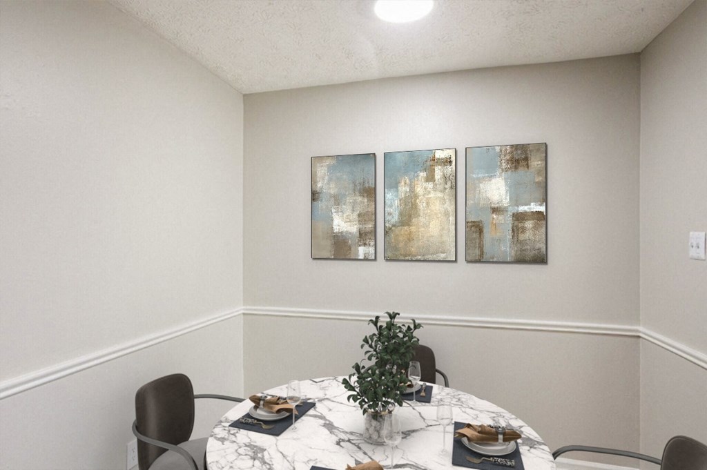 a dining room with a table and chairs and three paintings on the wall