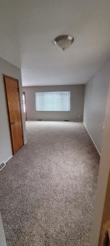 an empty room with a door and a white carpet