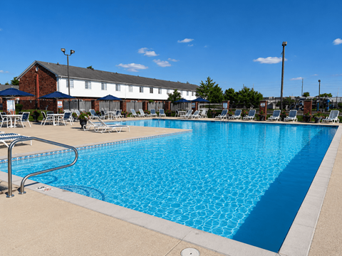 A large blue swimming pool with a metal railing on the left side.