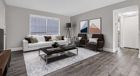 A living room with a white couch, a coffee table, and a rug.