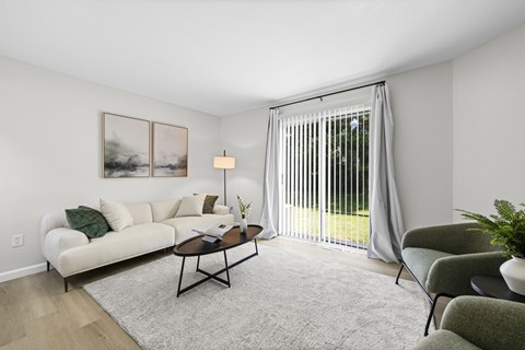 A living room with a white couch, a coffee table, and a painting on the wall.